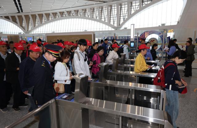 (260928) -- XI'AN, Sept. 28, 2026 (Xinhua) -- Passengers pass through ticket gates to board G9997, the first train of the Xi'an-Ankang high-speed railway, at Xi'an East Railway Station in Xi'an, northwest China's Shaanxi Province, Sept. 28, 2026. The Xi'an-Ankang high-speed railway was officially put into operation on Monday, cutting the railway travel time between Xi'an and Ankang to less than one hour. Spanning about 171 kilometers and with a design speed of 350 kilometers per hour, the railway runs through the cities of Xi'an, Shangluo and Ankang in Shaanxi Province and has five stations along the line. (Xinhua/Li Yibo)