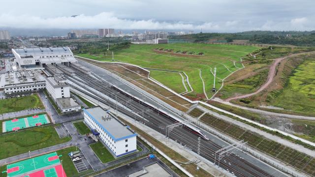(260928) -- XI'AN, Sept. 28, 2026 (Xinhua) -- An aerial drone photo shows G9997, the first train of the Xi'an-Ankang high-speed railway, arriving at Ankang West Station in northwest China's Shaanxi Province, Sept. 28, 2026. The Xi'an-Ankang high-speed railway was officially put into operation on Monday, cutting the railway travel time between Xi'an and Ankang to less than one hour. Spanning about 171 kilometers and with a design speed of 350 kilometers per hour, the railway runs through the cities of Xi'an, Shangluo and Ankang in Shaanxi Province and has five stations along the line. (Photo by Xiong Guodong/Xinhua)
