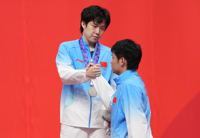 (260928) -- TOYOTA, Sept. 28, 2026 (Xinhua) -- Gold medalist Lin Shidong (R) of China shakes hands with silver medalist Wang Chuqin of China during the awarding ceremony for the men's singles of table tennis at the 20th Asian Games Aichi-Nagoya 2026 in Toyota of Aichi Prefecture, Japan, Sept. 28, 2026. (Xinhua/Cheong Kam Ka)