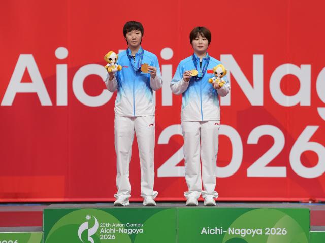 (260928) -- TOYOTA, Sept. 28, 2026 (Xinhua) -- Gold medalists Kuai Man (R)/Wang Manyu of China pose during the awarding ceremony for the women's doubles of table tennis at the 20th Asian Games Aichi-Nagoya 2026 in Toyota of Aichi Prefecture, Japan, Sept. 28, 2026. (Xinhua/Wang Fei)
