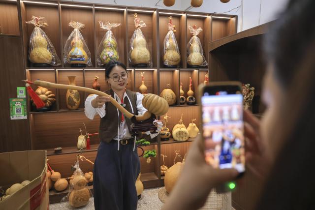 (260928) -- LIAOCHENG, Sept. 28, 2026 (Xinhua) -- A woman shows a gourd artwork in Tangyi Town, Liaocheng City of east China's Shandong Province, Sept. 28, 2026. Gourd cultivation and processing is a traditional industry in Tangyi Town of Liaocheng City, east China's Shandong Province. Local government has laid great importance on the development of the industry, regarding it as an impetus in its rural revitalization. 
  Nowadays, the planting area of gourd here has surpassed 10,000 mu (about 666.67 hectares), and the processing crafts have developed into 10 plus categories. (Xinhua/Yin Gang)