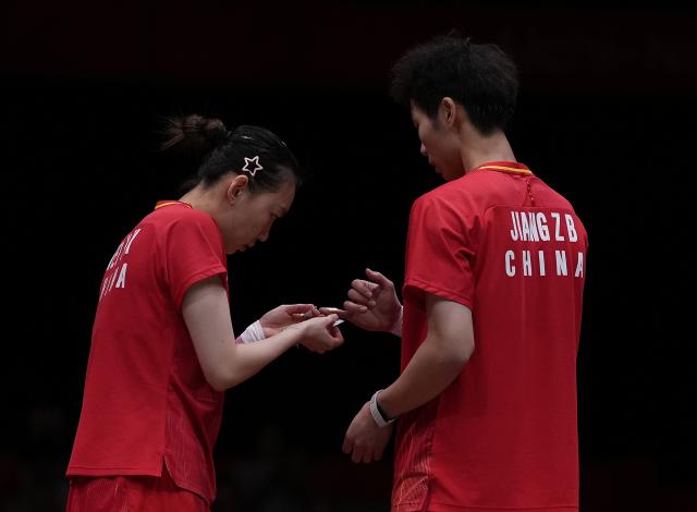 (260929) -- ICHINOMIYA, Sept. 29, 2026 (Xinhua) -- Wei Yaxin (L) of China helps taping the finger of her teammate Jiang Zhenbang during the mixed doubles final of badminton between Amri Syahnawi/Nita Violina Marwah of Indonesia and Jiang Zhenbang/Wei Yaxin of China at the 20th Asian Games Aichi-Nagoya 2026 in Ichinomiya of Aichi Prefecture, Japan, Sept. 29, 2026. (Xinhua/Li Bo)