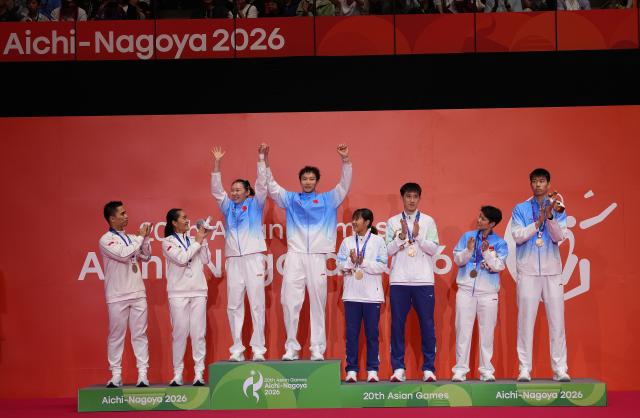 (260929) -- ICHINOMIYA, Sept. 29, 2026 (Xinhua) -- Silver medalists Amri Syahnawi/Nita Violina Marwah of Indonesia, gold medalists Wei Yaxin/Jiang Zhenbang of China, and bronze medalists Chan Nicole Gonzales/Ye Hong-Wei of Chinese Taipei, Huang Dongping/Feng Yanzhe of China (from L to R) react during the victory ceremony for the mixed doubles of badminton at the 20th Asian Games Aichi-Nagoya 2026 in Ichinomiya of Aichi Prefecture, Japan, Sept. 29, 2026. (Xinhua/Li Bo)