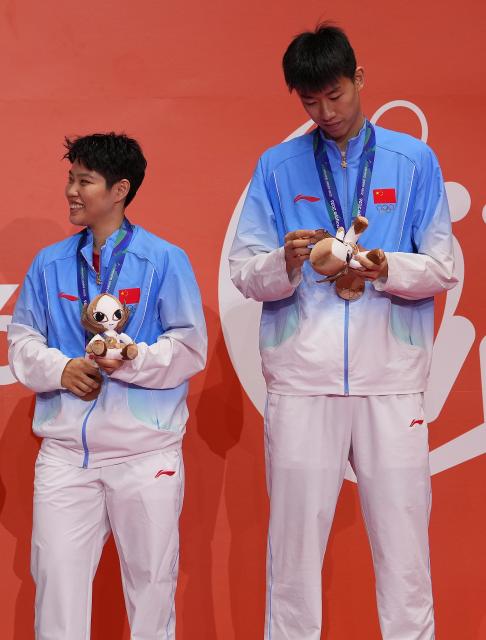 (260929) -- ICHINOMIYA, Sept. 29, 2026 (Xinhua) -- Bronze medalists Huang Dongping (L)/Feng Yanzhe of China react during the victory ceremony for the mixed doubles of badminton at the 20th Asian Games Aichi-Nagoya 2026 in Ichinomiya of Aichi Prefecture, Japan, Sept. 29, 2026. (Xinhua/Li Bo)