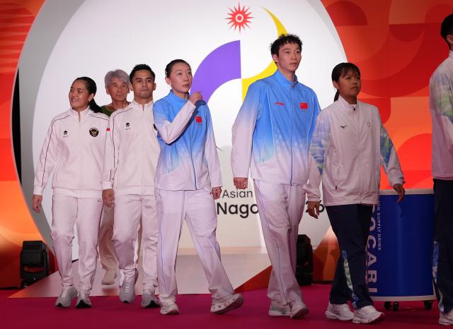 (260929) -- ICHINOMIYA, Sept. 29, 2026 (Xinhua) -- Gold medalists Jiang Zhenbang (2nd R)/Wei Yaxin (3rd R) of China arrive for the victory ceremony for the mixed doubles of badminton at the 20th Asian Games Aichi-Nagoya 2026 in Ichinomiya of Aichi Prefecture, Japan, Sept. 29, 2026. (Xinhua/Li Bo)