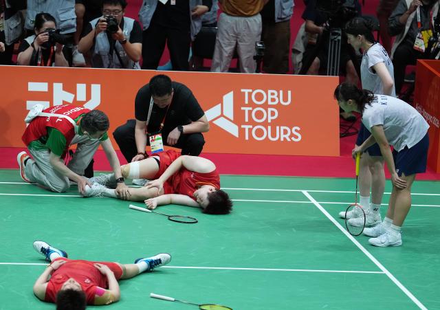 (260929) -- ICHINOMIYA, Sept. 29, 2026 (Xinhua) -- Liu Shengshu (L, top)/Tan Ning (L, bottom) of China react as Lee Sohee (R, top)/Baek Hana (L, top) of South Korea look on after the women's doubles final of badminton at the 20th Asian Games Aichi-Nagoya 2026 in Ichinomiya of Aichi Prefecture, Japan, Sept. 29, 2026. (Xinhua/Cheong Kam Ka)