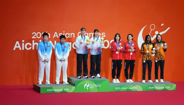 (260929) -- ICHINOMIYA, Sept. 29, 2026 (Xinhua) -- Gold medalists Lee Sohee (3rd L)/Baek Hana (4th L) of South Korea, silver medalists Liu Shengshu (1st L)/Tan Ning (2nd L) of China, bronze medalists Nakanishi Kie (4th R)/Uesaka Rin (3rd R) of Japan and Tan Pearly Koong Le (1st R)/Thinaah Muralitharan of Malaysia pose for photos during the victory ceremony for the women's doubles of badminton at the 20th Asian Games Aichi-Nagoya 2026 in Ichinomiya of Aichi Prefecture, Japan, Sept. 29, 2026. (Xinhua/Cheong Kam Ka)