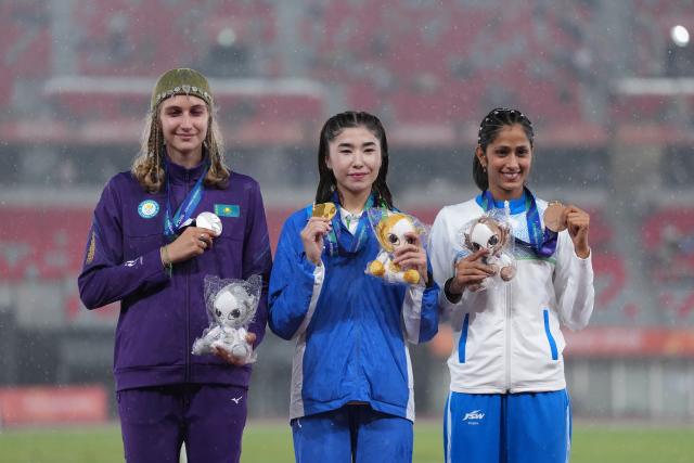 (260929) -- NAGOYA, Sept. 29, 2026 (Xinhua) -- Gold medalist Barnokhon Sayfullaeva (C) of Uzbekistan, silver medalist Kristina Ovchinnikova (L) of Kazakhstan, bronze medalist Pooja of India pose for photos during the awarding ceremony for the women's high jump final of Athletics at the 20th Asian Games Aichi-Nagoya 2026 in Nagoya, Japan, Sept. 29, 2026. (Xinhua/Jia Yuchen)