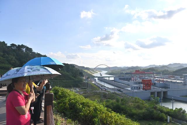 (260929) -- QINZHOU, Sept. 29, 2026 (Xinhua) -- Tourists enjoy sightseeing at a viewing platform of the Madao hub on the Pinglu Canal in south China's Guangxi Zhuang Autonomous Region, Sept. 29, 2026. Tourism is booming along the Pinglu Canal in Guangxi recently. Many tourists take boat tours to view waterways, navigation hubs and bridges of the canal and enjoy the scenery along it. 
  The Pinglu Canal, officially opened to navigation on Sept. 16, links the Xijiang River shipping route with the Beibu Gulf, acting as a vital link connecting China's inland waterways with the sea. (Xinhua/Zhou Hua)