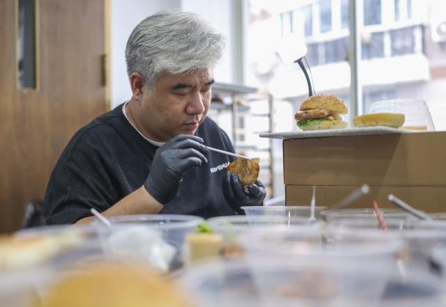 (260929) -- SHANGHAI, Sept. 29, 2026 (Xinhua) -- Li Haohan works on a hamburger at his studio in Shanghai, east China, Sept. 24, 2026. Unlike chefs who prioritize flavor, food stylists handle various ingredients, arrange plates and use tools to create the desired visual effects, capturing food's most appealing moments.
   Li Haohan has been engaged in food styling for more than 20 years. 
Li used to be a pastry chef. In 2003, he was invited to participate in a commercial shoot on instant noodles, where his outstanding craftsmanship earned him recognition. Since then, Li started to work as a part-time food stylist.
   In 2010, Li became a professional food stylist and founded a food styling studio. Today, his team has grown to over 20 members, forming a professional team with deep expertise in food styling in China. (Xinhua/Chen Haoming)