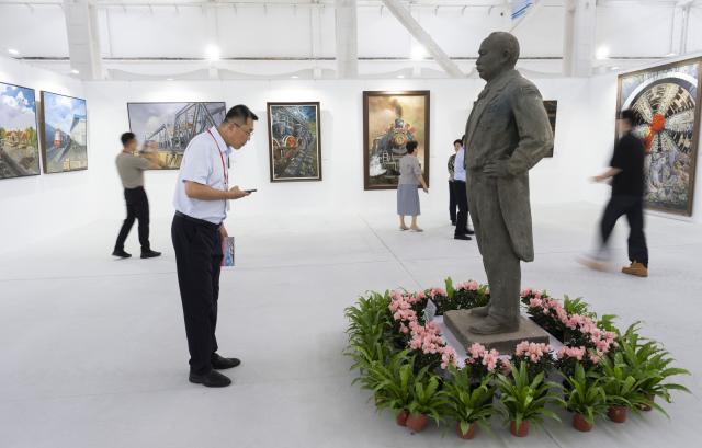 (260929) -- BEIJING, Sept. 29, 2026 (Xinhua) -- A man looks at a sculpture of Zhan Tianyou, known as the "Father of China's railroad," during a railway-themed art exhibition at a CRRC intelligent manufacturing park in Beijing, capital of China, Sept. 29, 2026. A railway culture and art week kicked off in Beijing on Tuesday, with a railway-themed art exhibition displaying over 1,200 exhibits covering painting, sculpture, carving and paper cutting. (Xinhua/Cai Yang)