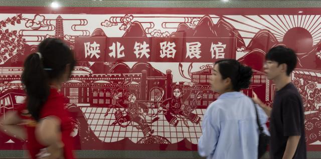 (260929) -- BEIJING, Sept. 29, 2026 (Xinhua) -- People view a paper-cutting artwork during a railway-themed art exhibition at a CRRC intelligent manufacturing park in Beijing, capital of China, Sept. 29, 2026. A railway culture and art week kicked off in Beijing on Tuesday, with a railway-themed art exhibition displaying over 1,200 exhibits covering painting, sculpture, carving and paper cutting. (Xinhua/Cai Yang)