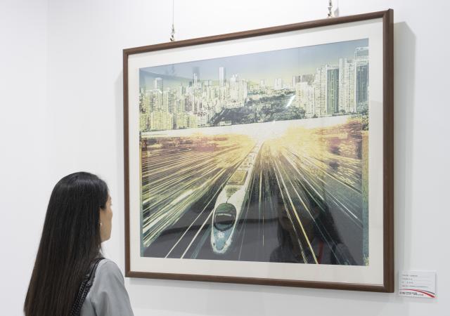 (260929) -- BEIJING, Sept. 29, 2026 (Xinhua) -- A woman views a painting during a railway-themed art exhibition at a CRRC intelligent manufacturing park in Beijing, capital of China, Sept. 29, 2026. A railway culture and art week kicked off in Beijing on Tuesday, with a railway-themed art exhibition displaying over 1,200 exhibits covering painting, sculpture, carving and paper cutting. (Xinhua/Cai Yang)