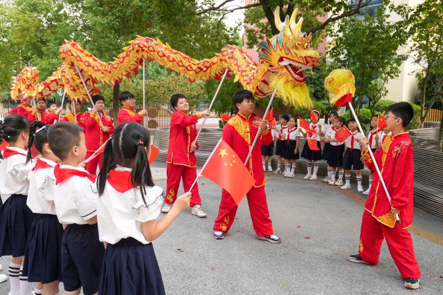 (260929) -- BEIJING, Sept. 29, 2026 (Xinhua) -- Students watch a dragon-dance performance in Xinghua City, east China's Jiangsu Province, Sept. 29, 2026. Various events are held across China in celebration of the upcoming National Day. (Photo by Zhou Shegen/Xinhua)