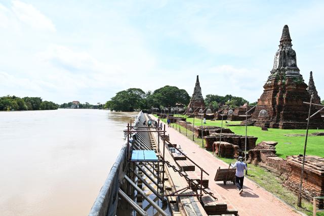 (260929) -- AYUTTHAYA, Sept. 29, 2026 (Xinhua) -- Workers install flood barriers to protect Wat Chaiwatthanaram from flooding in Ayutthaya, Thailand, Sept. 29, 2026. Thailand's Department of Disaster Prevention and Mitigation reported that, as of the evening of Sept. 28, flooding since Sept. 16 had killed 23 people nationwide and affected more than 2.5 million others. (Xinhua/Rachen Sageamsak)
