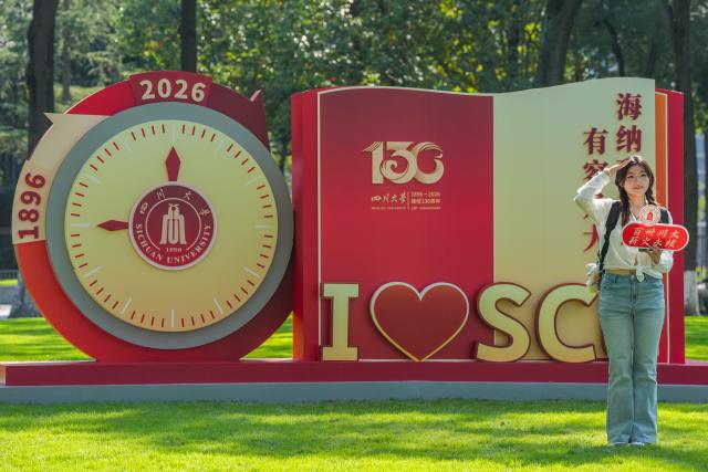 (260930) -- CHENGDU, Sept. 30, 2026 (Xinhua) -- A student poses for photos in front of a sign marking the 130th anniversary of the founding of Sichuan University at its Wangjiang Campus in Chengdu, southwest China's Sichuan Province, Sept. 29, 2026. An event celebrating the 130th anniversary of the founding of Sichuan University was held in Chengdu on Tuesday. (Xinhua/Wang Xi)