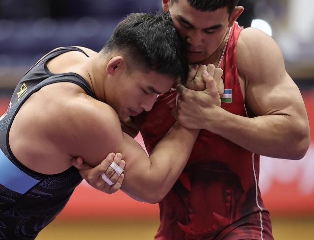 (260930) -- NAGOYA, Sept. 30, 2026 (Xinhua) -- Shi Likui (L) of China competes with Jalgasbay Berdimuratov of Uzbekistan during the Men's Greco-Roman 87kg 1/8 Finals of Wrestling at the 20th Asian Games Aichi-Nagoya 2026 in Nagoya, Japan, Sept. 30, 2026. (Xinhua/Long Lei)