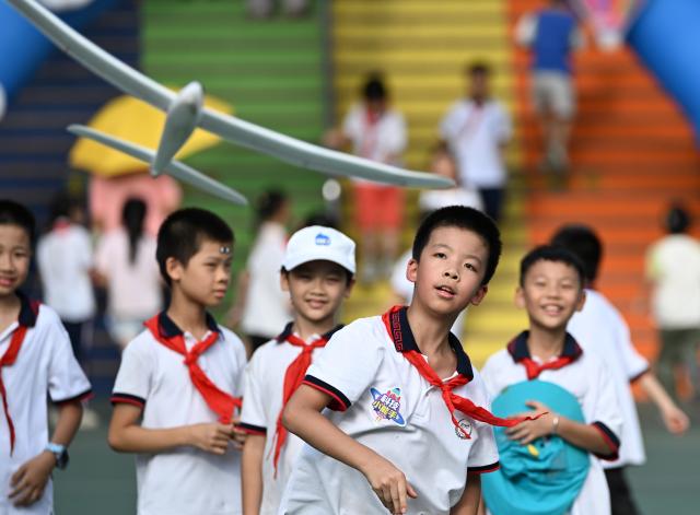 (260930) -- WUZHOU, Sept. 30, 2026 (Xinhua) -- A student flies a model plane during a science festival at a primary school in Wuzhou, south China's Guangxi Zhuang Autonomous Region, Sept. 29, 2026. The science event was held on Tuesday at the primary school to mark the upcoming National Day. (Xinhua/Huang Xiaobang)
