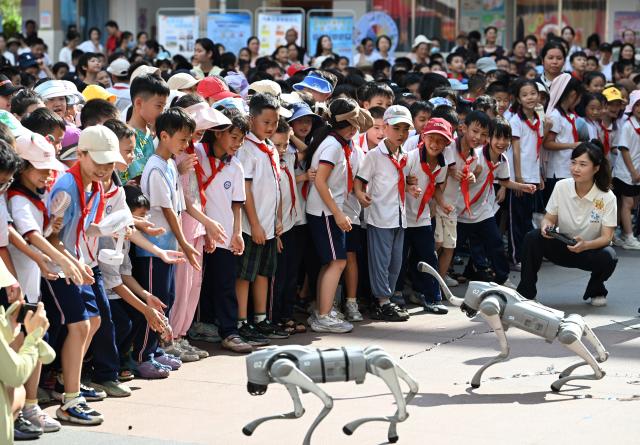 (260930) -- WUZHOU, Sept. 30, 2026 (Xinhua) -- Students watch a robot dog performance during a science festival at a primary school in Wuzhou, south China's Guangxi Zhuang Autonomous Region, Sept. 29, 2026. The science event was held on Tuesday at the primary school to mark the upcoming National Day. (Xinhua/Huang Xiaobang)