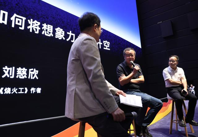 (260930) -- SHANGHAI, Sept. 30, 2026 (Xinhua) -- Liu Cixin (C) talks with guests and audiences during the launch event for an immersive sci-fi fairy-tale experience space inspired by his "The Fire Keeper" at the Shanghai Science and Technology Museum in Shanghai, east China, Sept. 29, 2026. A launch event for an immersive sci-fi fairy-tale experience space inspired by writer Liu Cixin's "The Fire Keeper" was held here on Tuesday. (Xinhua/Fang Zhe)