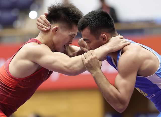(260930) -- NAGOYA, Sept. 30, 2026 (Xinhua) -- Leng Ji (L) of China competes with Aytjan Khalmakhanov of Uzbekistan during the Men's Greco-Roman 67kg 1/8 Finals of Wrestling at the 20th Asian Games Aichi-Nagoya 2026 in Nagoya, Japan, Sept. 30, 2026. (Xinhua/Long Lei)