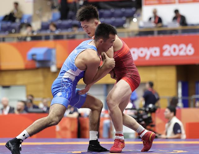 (260930) -- NAGOYA, Sept. 30, 2026 (Xinhua) -- Leng Ji (R) of China competes with Aytjan Khalmakhanov of Uzbekistan during the Men's Greco-Roman 67kg 1/8 Finals of Wrestling at the 20th Asian Games Aichi-Nagoya 2026 in Nagoya, Japan, Sept. 30, 2026. (Xinhua/Long Lei)