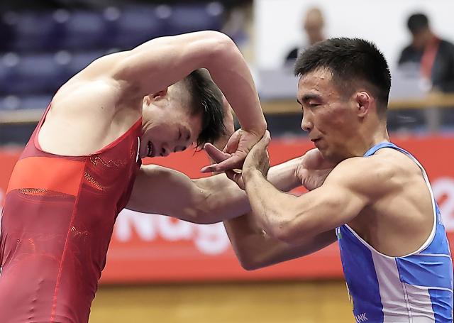 (260930) -- NAGOYA, Sept. 30, 2026 (Xinhua) -- Leng Ji (L) of China competes with Aytjan Khalmakhanov of Uzbekistan during the Men's Greco-Roman 67kg 1/8 Finals of Wrestling at the 20th Asian Games Aichi-Nagoya 2026 in Nagoya, Japan, Sept. 30, 2026. (Xinhua/Long Lei)