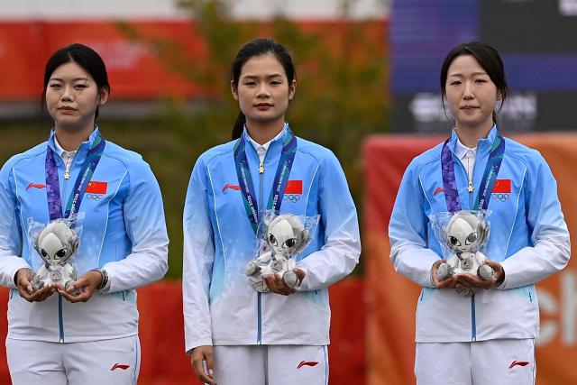 (260930) -- OKAZAKI, Sept. 30, 2026 (Xinhua) -- Silver medalists Wunier (R), Wang Yue (L), Wei Fangyao of team China react during the victory ceremony for the compound women's team of archery at the 20th Asian Games Aichi-Nagoya 2026 in Okazaki of Aichi Prefecture, Japan, Sept. 30, 2026. (Xinhua/Yu Yang)