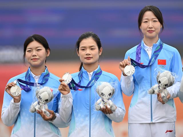 (260930) -- OKAZAKI, Sept. 30, 2026 (Xinhua) -- Silver medalists Wunier (R), Wang Yue (L), Wei Fangyao of team China pose for photos during the victory ceremony for the compound women's team of archery at the 20th Asian Games Aichi-Nagoya 2026 in Okazaki of Aichi Prefecture, Japan, Sept. 30, 2026. (Xinhua/Yu Yang)