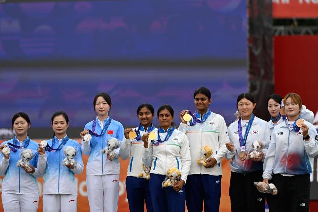 (260930) -- OKAZAKI, Sept. 30, 2026 (Xinhua) -- Gold medalists Chikitha Taniparthi (C), Prithika Pradeep (4th L), Jyothi Surekha Vennam (4th R) of team India, silver medalists Wunier (3rd L), Wang Yue (1st L), Wei Fangyao (2nd L) of team China, bronze medalists Park Jungyoon (2nd R), Park Yerin (1st R), Kang Yeonseo of team South Korea pose for photos during the victory ceremony for the compound women's team of archery at the 20th Asian Games Aichi-Nagoya 2026 in Okazaki of Aichi Prefecture, Japan, Sept. 30, 2026. (Xinhua/Yu Yang)