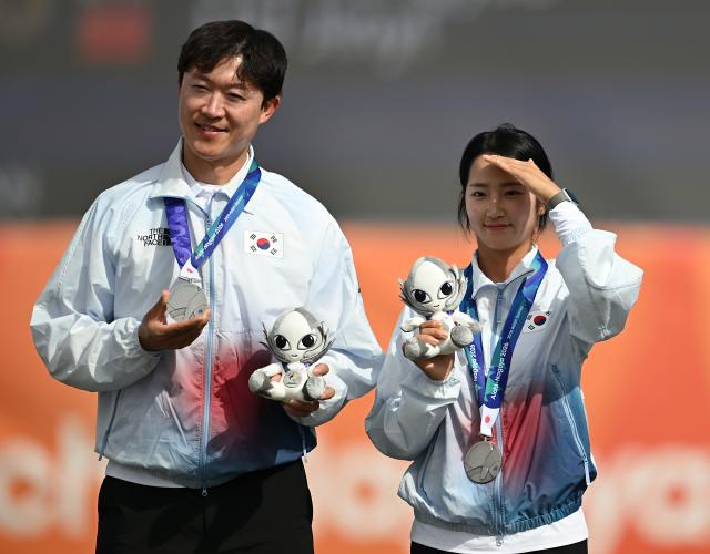 (260930) -- OKAZAKI, Sept. 30, 2026 (Xinhua) -- Silver medalists Park Jungyoon (R) and Choi Yonghee of South Korea pose for photos during the victory ceremony for the compound mixed team of archery at the 20th Asian Games Aichi-Nagoya 2026 in Okazaki of Aichi Prefecture, Japan, Sept. 30, 2026. (Xinhua/Yu Yang)