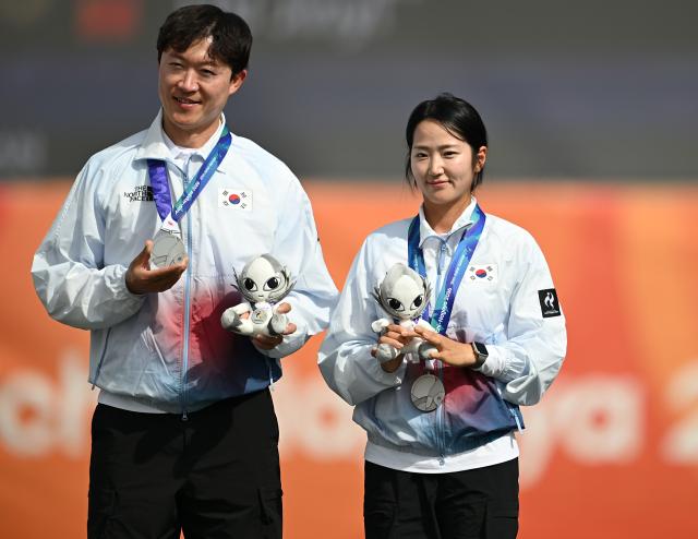 (260930) -- OKAZAKI, Sept. 30, 2026 (Xinhua) -- Silver medalists Park Jungyoon (R) and Choi Yonghee of South Korea pose for photos during the victory ceremony for the compound mixed team of archery at the 20th Asian Games Aichi-Nagoya 2026 in Okazaki of Aichi Prefecture, Japan, Sept. 30, 2026. (Xinhua/Yu Yang)