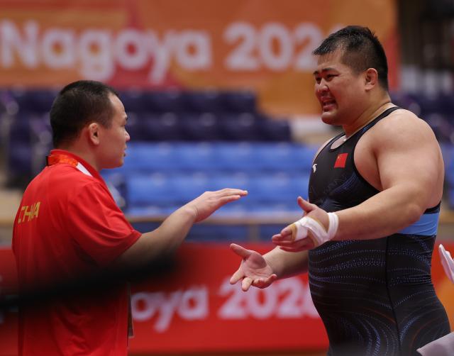 (260930) -- NAGOYA, Sept. 30, 2026 (Xinhua) -- Meng Lingzhe (R) of China talks with his coach while competing with Amin Mirzazadeh of Iran during the Men's Greco-Roman 130kg Semifinals of Wrestling at the 20th Asian Games Aichi-Nagoya 2026 in Nagoya, Japan, Sept. 30, 2026. (Xinhua/Li Bo)