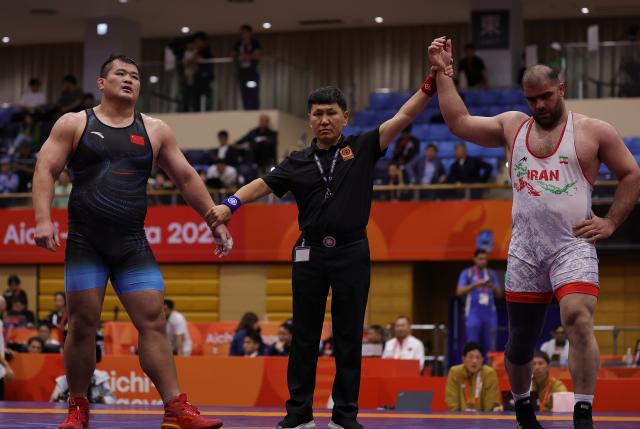 (260930) -- NAGOYA, Sept. 30, 2026 (Xinhua) -- Meng Lingzhe (L) of China and Amin Mirzazadeh of Iran react after the Men's Greco-Roman 130kg Semifinals of Wrestling at the 20th Asian Games Aichi-Nagoya 2026 in Nagoya, Japan, Sept. 30, 2026. (Xinhua/Li Bo)