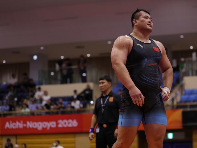 (260930) -- NAGOYA, Sept. 30, 2026 (Xinhua) -- Meng Lingzhe (R) of China reacts after competing with Amin Mirzazadeh of Iran during the Men's Greco-Roman 130kg Semifinals of Wrestling at the 20th Asian Games Aichi-Nagoya 2026 in Nagoya, Japan, Sept. 30, 2026. (Xinhua/Li Bo)