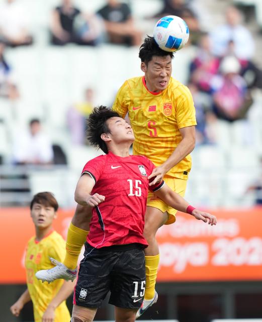 (260930) -- OSAKA, Sept. 30, 2026 (Xinhua) -- Zhu Chenjie (top) of China vies for header with Hwang Doyun of South Korea during the men's semifinals of football between China and South Korea at 20th Asian Games Aichi-Nagoya 2026 in Osaka, Japan, Sept. 30, 2026. (Xinhua/Lui Siu Wai)