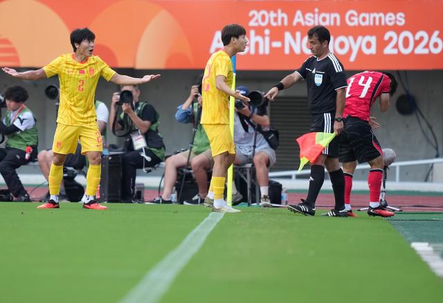(260930) -- OSAKA, Sept. 30, 2026 (Xinhua) -- Mao Weijie (2nd L) of China communicates with an assistant referee during the men's semifinals of football between China and South Korea at 20th Asian Games Aichi-Nagoya 2026 in Osaka, Japan, Sept. 30, 2026. (Xinhua/Lui Siu Wai)
