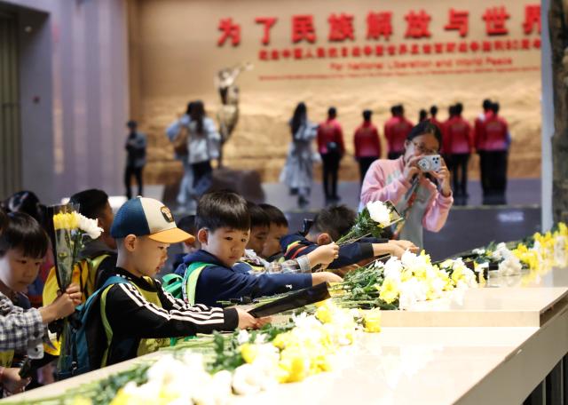 (260930) -- BEIJING, Sept. 30, 2026 (Xinhua) -- Children lay flowers while visiting the Museum of the War of the Chinese People's Resistance Against Japanese Aggression in Beijing, capital of China, Sept. 30, 2026. China observed its 13th Martyrs' Day on Wednesday with commemorations held here to honor fallen national heroes. (Xinhua/Zhang Chenlin)