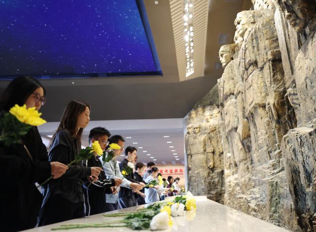 (260930) -- BEIJING, Sept. 30, 2026 (Xinhua) -- People lay flowers while visiting the Museum of the War of the Chinese People's Resistance Against Japanese Aggression in Beijing, capital of China, Sept. 30, 2026. China observed its 13th Martyrs' Day on Wednesday with commemorations held here to honor fallen national heroes. (Xinhua/Zhang Chenlin)