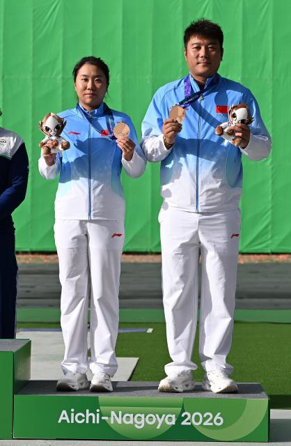 (260930) -- TOYOTA, Sept. 30, 2026 (Xinhua) -- Bronze medalists Qi Ying (R) and Sun Yunong of team China pose for photos during the victory ceremony for the trap mixed team of shooting at the 20th Asian Games Aichi-Nagoya 2026 in Toyota of Aichi Prefecture, Japan, Sept. 30, 2026. (Xinhua/Liu Lei)