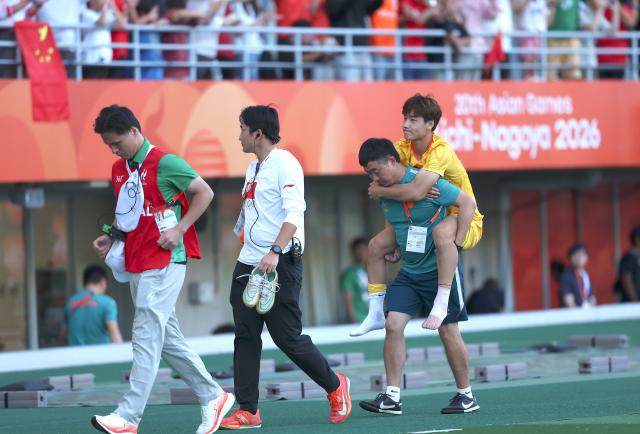 (260930) -- OSAKA, Sept. 30, 2026 (Xinhua) -- Mao Weijie (1st R) leaves the court after the men's football semifinal between China and South Korea at 20th Asian Games Aichi-Nagoya 2026 in Osaka, Japan, Sept. 30, 2026. (Xinhua/Jia Haocheng)