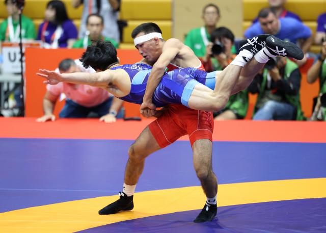 (260930) -- NAGOYA, Sept. 30, 2026 (Xinhua) -- Uzbekistan's Aytjan Khalmakhanov (R) competes with Japan's Sogabe Kyotaro during the Men's Greco-Roman 67kg finals of Wrestling at the 20th Asian Games Aichi-Nagoya 2026 in Nagoya, Japan, Sept. 30, 2026. (Xinhua/Long Lei)