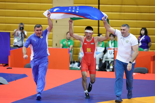 (260930) -- NAGOYA, Sept. 30, 2026 (Xinhua) -- Uzbekistan's Aytjan Khalmakhanov (C) celebrates after winning Japan's Sogabe Kyotaro during the Men's Greco-Roman 67kg finals of Wrestling at the 20th Asian Games Aichi-Nagoya 2026 in Nagoya, Japan, Sept. 30, 2026. (Xinhua/Long Lei)