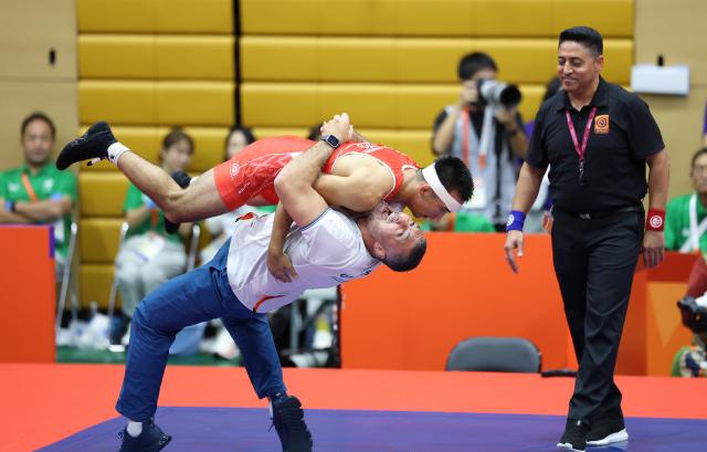 (260930) -- NAGOYA, Sept. 30, 2026 (Xinhua) -- Uzbekistan's Aytjan Khalmakhanov (top, L) celebrates after winning Japan's Sogabe Kyotaro during the Men's Greco-Roman 67kg finals of Wrestling at the 20th Asian Games Aichi-Nagoya 2026 in Nagoya, Japan, Sept. 30, 2026. (Xinhua/Long Lei)