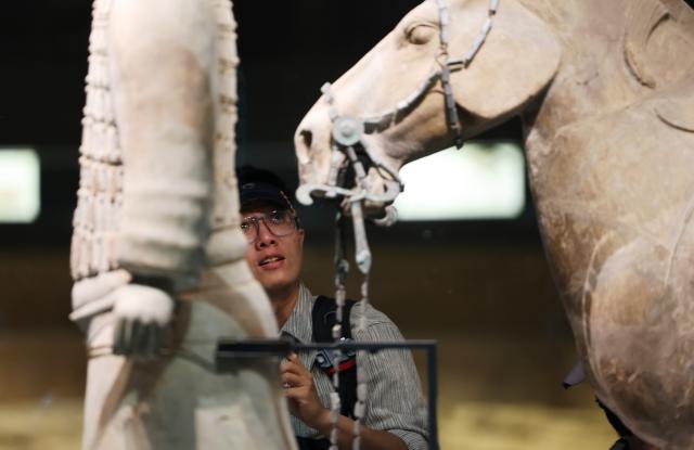 (260930) -- XI'AN, Sept. 30, 2026 (Xinhua) -- A visitor admires exhibits at the Pit No. 2 exhibition hall of the Emperor Qinshihuang's Mausoleum Site Museum in Xi'an, northwest China's Shaanxi Province, Sept. 30, 2026. The Pit No. 2 exhibition hall of the Emperor Qinshihuang's Mausoleum Site Museum has completed its renovation and will be open to the public during the National Day holiday. (Xinhua/Li Yibo)