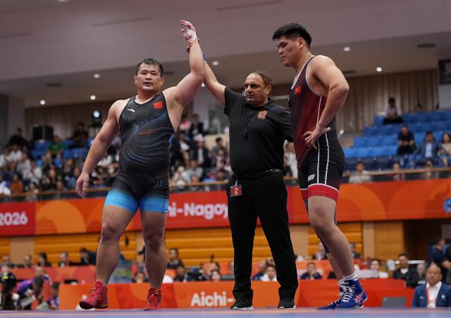 (260930) -- NAGOYA, Sept. 30, 2026 (Xinhua) -- Meng Lingzhe (L) of China celebrates victory after winning the men's greco-roman 130kg bronze medal match of Wrestling against Murat Zarlykbekovich Botoev of Kyrgyzstan at the 20th Asian Games Aichi-Nagoya 2026 in Nagoya, Japan, Sept. 30, 2026. (Xinhua/Li Bo)