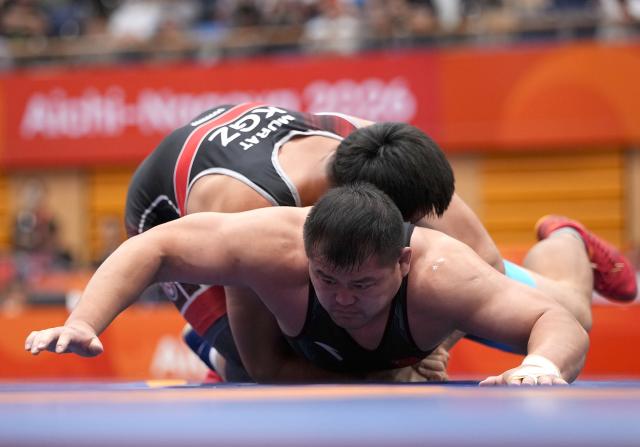 (260930) -- NAGOYA, Sept. 30, 2026 (Xinhua) -- Meng Lingzhe (bottom) of China competes against Murat Zarlykbekovich Botoev of Kyrgyzstan during the men's greco-roman 130kg bronze medal match of Wrestling at the 20th Asian Games Aichi-Nagoya 2026 in Nagoya, Japan, Sept. 30, 2026. (Xinhua/Li Bo)