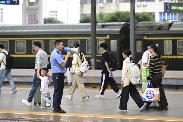 (260930) -- BEIJING, Sept. 30, 2026 (Xinhua) -- A staff member guides passengers at a platform of Hefei Railway Station in Hefei, east China's Anhui Province, Sept. 30, 2026. China's railway network saw a peak in passenger flow on Wednesday, one day before the beginning of the seven-day National Day holiday. (Xinhua/Zhou Mu)