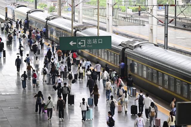 (260930) -- BEIJING, Sept. 30, 2026 (Xinhua) -- Passengers are on their way to board a train at Hefei Railway Station in Hefei, east China's Anhui Province, Sept. 30, 2026. China's railway network saw a peak in passenger flow on Wednesday, one day before the beginning of the seven-day National Day holiday. (Xinhua/Zhou Mu)