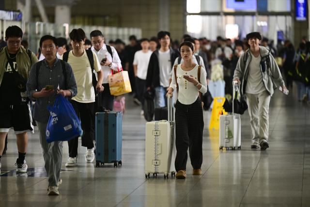 (260930) -- BEIJING, Sept. 30, 2026 (Xinhua) -- Passengers are seen at Hefei Railway Station in Hefei, east China's Anhui Province, Sept. 30, 2026. China's railway network saw a peak in passenger flow on Wednesday, one day before the beginning of the seven-day National Day holiday. (Xinhua/Zhou Mu)